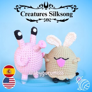 Puede incluir: Dos criaturas hechas a mano con ganchillo. Una es rosa con ojos negros y blancos, la otra es marrón con detalles en rosa. La imagen incluye el texto "Creatures Silksong" y el identificador de Instagram del vendedor.