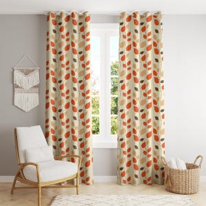 Op de afbeelding: Beige gordijnen met een herhalend patroon van oranje, bruine en bruine bladeren op dunne stelen. De gordijnen hangen voor een raam, met een witte stoel en een rieten mand op de voorgrond.