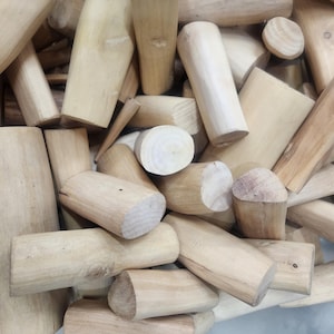 Könnte beinhalten: Nahaufnahme eines Stapels hellbrauner Holzstäbe. Die Stäbe sind in verschiedenen Größen und Formen, und einige haben eine leicht raue Textur.