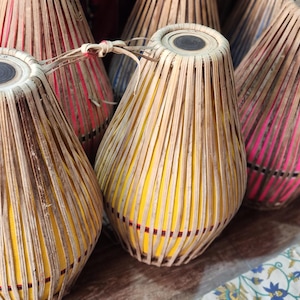 Puede incluir: Una colección de tambores tradicionales indios, conocidos como tabla, hechos de madera y cuero. Los tambores están decorados con intrincados patrones y están dispuestos en una fila sobre una superficie de madera.