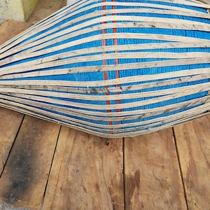 Puede incluir: Un tambor azul y marrón con un diseño tejido. El tambor está hecho de madera y tiene una cubierta de tela azul.