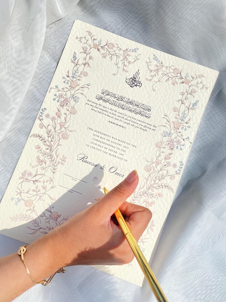May include: A cream-coloured marriage certificate with floral border and Arabic calligraphy. The document includes text in English and Arabic, with the names Raeesa & Omer. A gold pen is held over the document.