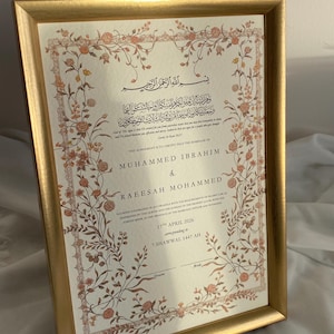 May include: A framed marriage certificate with a gold border. The certificate features floral designs in peach and brown. The names "MUHAMMED IBRAHIM" and "RAEESAH MOHAMMED" are displayed, alongside Arabic script and the date "17th April 2026".