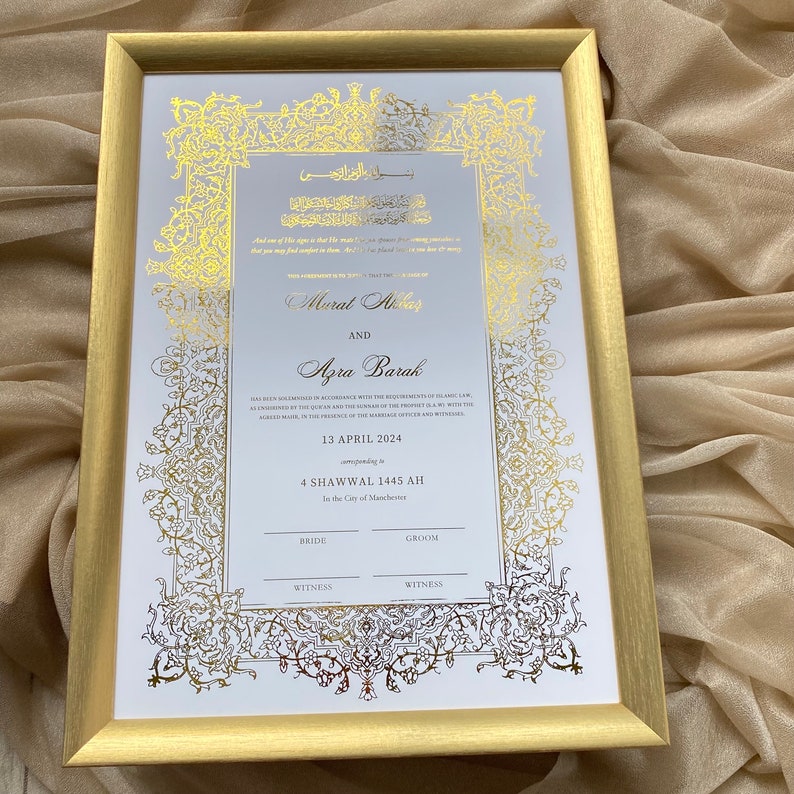 May include: A gold-framed wedding certificate with ornate calligraphy and floral designs. The text reads "Morat Abbas and Azra Barak" and includes the date "13 April 2024" and the location "In the City of Manchester".