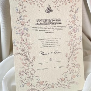 May include: A cream-coloured wedding certificate featuring a floral border in pink and blue. The document includes Arabic calligraphy and English text from Surah Ar-Rum 21, with spaces for names and dates. The certificate is for Raeesa & Omer.
