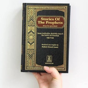 Può includere: Un libro rilegato in nero con dettagli dorati e il titolo "Stories Of The Prophets [Peace be upon them!"  Il libro è di Imam Imaduddin Abul-Fida Isma'il Ibn Kathir Ad-Dimashqi, 700-774H. È stato tradotto in inglese da Rashad Ahmad Azami e pubblicato da Darussalam.
