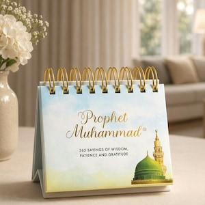Peut inclure: Un calendrier de bureau avec une reliure spirale dorée présente les mots "Prophète Muhammad" en script doré. Le calendrier comprend une illustration d'une mosquée et le texte "365 paroles de sagesse, de patience et de gratitude."
