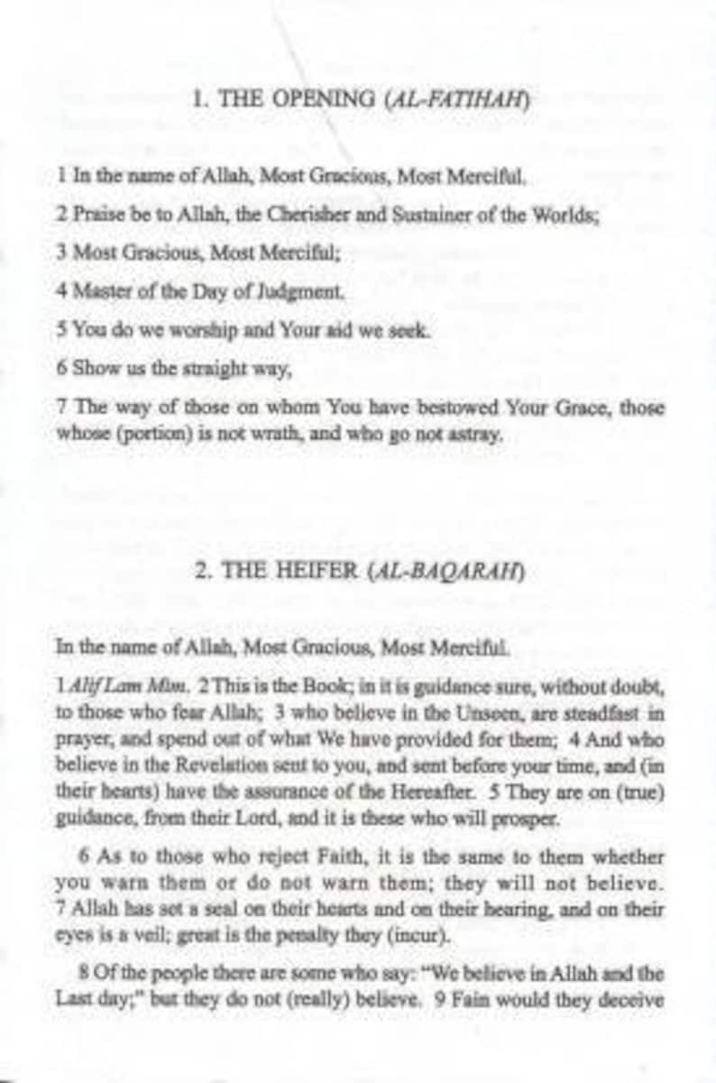 May include: A black and white printed page with the first two chapters of the Quran, titled "The Opening (Al-Fatihah)" and "The Heifer (Al-Baqarah)".