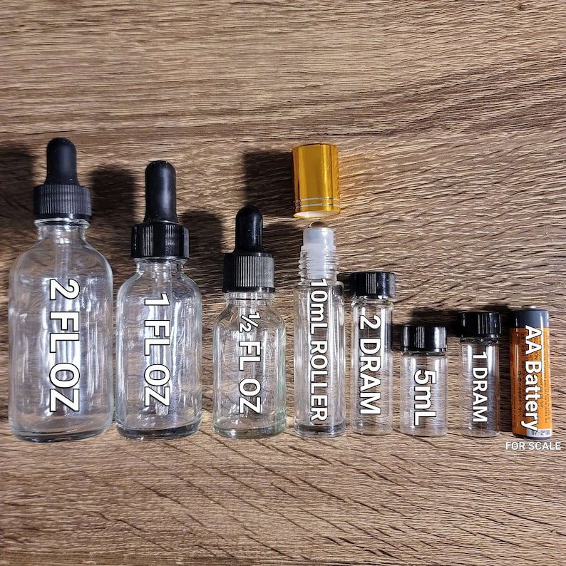 Puede incluir: Un juego de ocho botellas de vidrio con goteros y bolas rodantes de varios tama&ntilde;os, que van desde 1/2 onza l&iacute;quida hasta 2 onzas l&iacute;quidas. Las botellas son de vidrio transparente y tienen goteros y tapas negras. La botella de bola rodante es de 10 mililitros. Las botellas est&aacute;n dispuestas en orden de tama&ntilde;o, con la botella m&aacute;s grande a la izquierda y la m&aacute;s peque&ntilde;a a la derecha. Se incluye una bater&iacute;a AA para la escala.