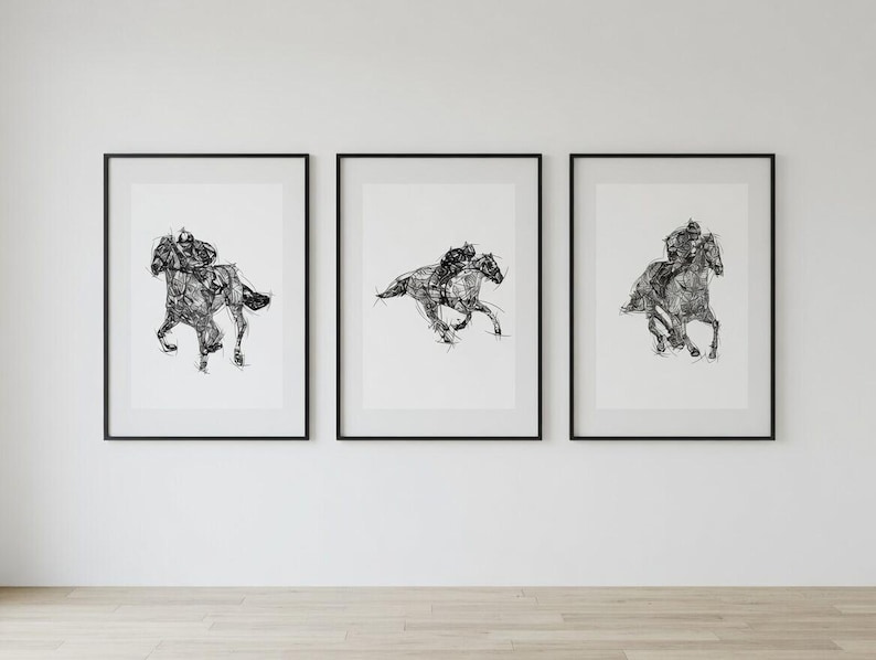 May include: Three framed black and white art prints of racehorses and jockeys. Each print features a detailed sketch of a horse in motion, with a jockey riding. The prints are displayed on a white wall.