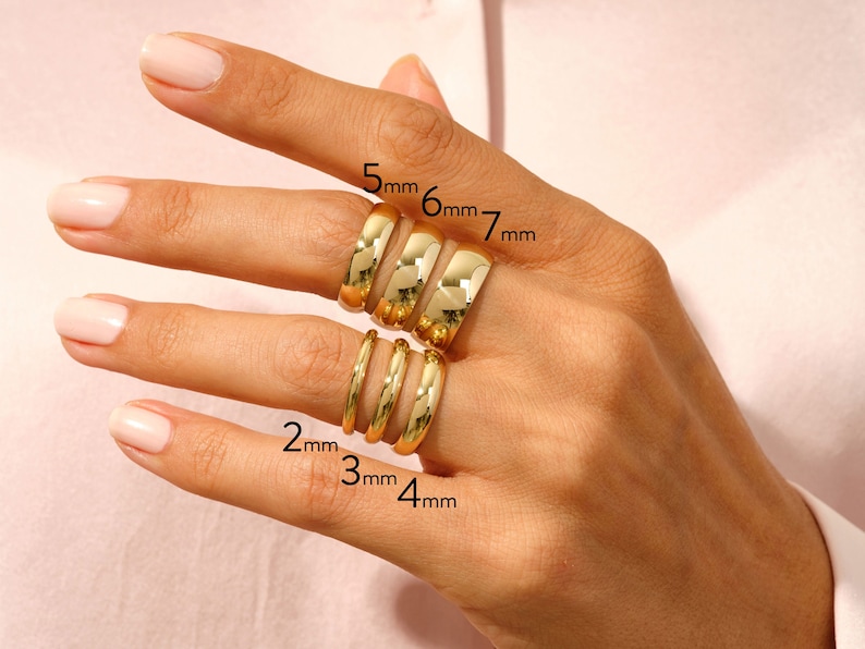 K&ouml;nnte beinhalten: Ein Satz von sechs goldfarbenen Ringen, die auf einem Finger gestapelt sind. Die Ringe sind mit ihren Breiten in Millimetern beschriftet: 2 mm, 3 mm, 4 mm, 5 mm, 6 mm und 7 mm.