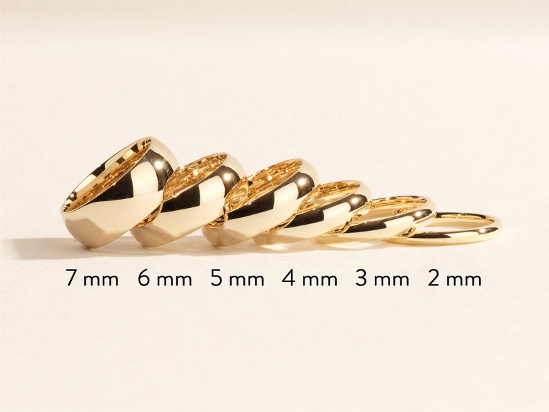 K&ouml;nnte beinhalten: Ein Satz von sechs goldenen Ringen, jeder mit einer anderen Breite, von 2 mm bis 7 mm. Die Ringe sind nach Gr&ouml;&szlig;e geordnet, der gr&ouml;&szlig;te Ring links und der kleinste Ring rechts.