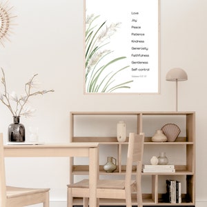 K&ouml;nnte beinhalten: Ein gerahmter Druck mit einer Aquarell-Illustration von gr&uuml;nem Gras und wei&szlig;en Blumen. Der Druck zeigt eine Liste von Tugenden: Liebe, Freude, Friede, Geduld, Freundlichkeit, Gro&szlig;z&uuml;gigkeit, Treue, Sanftmut und Selbstbeherrschung. Der Text "Galater 5,22-25" ist unten auf dem Druck gedruckt.