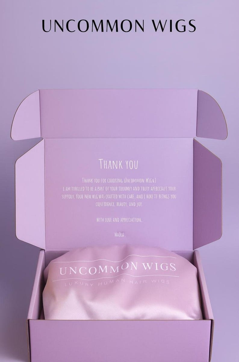 May include: A light purple cardboard shipping box containing a soft pink satin pouch. The box lid features the text UNCOMMON WIGS and a thank you note. The pink pouch is printed with the text UNCOMMON WIGS LUXURY HUMAN HAIR WIGS in white.