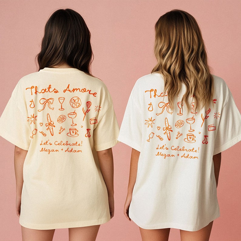 May include: Two white t-shirts with a cream t-shirt. The shirts have a red graphic with the text "That's Amore" and "Let's Celebrate! Megan + Adam".