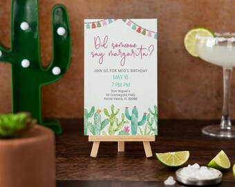 Op de afbeelding: Een cactus-thema verjaardagsuitnodiging met de tekst "Did someone say margarita?" en details voor een feest op 16 mei om 19:00 uur. De uitnodiging staat op een klein ezel met een margarita-glas en limoenpartjes op de achtergrond.