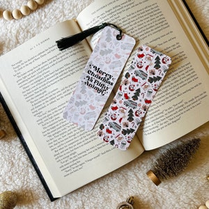 May include: Two Christmas-themed bookmarks with a white background and red, green, and white illustrations. The bookmarks feature a variety of Christmas-themed images, including a Christmas tree, a stocking, a gift, a candy cane, a gingerbread man, a snowman, a Santa Claus, a reindeer, a snowflake, a bell, a star, and a present. The text on the bookmarks reads "Merry Christmas Ya Filthy Animal".