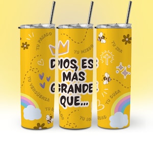 May include: Three yellow stainless steel tumblers with a motivational quote in Spanish that reads "Dios es mas grande que..."  The tumblers are decorated with a variety of colorful illustrations including hearts, bees, flowers, a crown, a cross, and a rainbow.