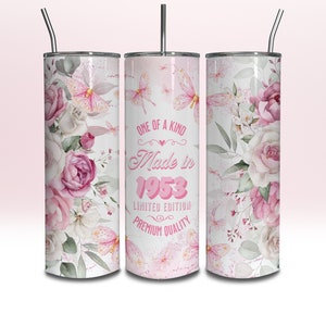 May include: Three stainless steel tumblers with pink floral designs and butterflies. The centre tumbler has the text "One of a Kind Made in 1953 Limited Edition Premium Quality".