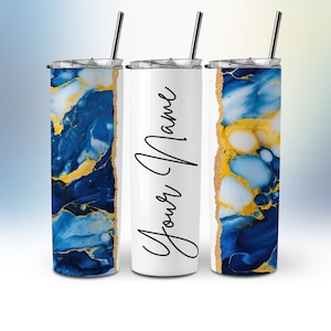 Op de afbeelding: Drie roestvrijstalen bekers met deksels en rietjes. De bekers hebben een blauw en gouden marmerpatroon met een gouden folie-accent. De middelste beker is wit met de tekst "Your Name" in zwarte cursieve letters.