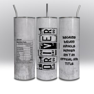 May include: A white stainless steel tumbler with a black graphic that reads "Driver" with a nutrition facts label on the left side and "Because badass miracle worker isn't an official job title" on the right side.