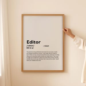 Könnte beinhalten: Ein gerahmter Druck mit weißem Hintergrund und schwarzem Text, der das Wort "Editor" definiert. Der Text enthält die Aussprache, die Definition und eine humorvolle Beschreibung der Rolle eines Editors.