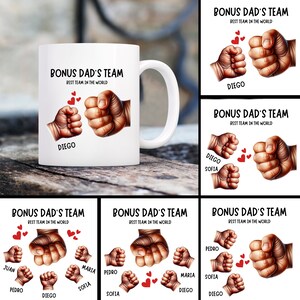 May include: White ceramic mug with a brown fist and a smaller fist, with the text "Bonus Dad's Team Best Team in the World" and the name "Diego" printed on the mug.