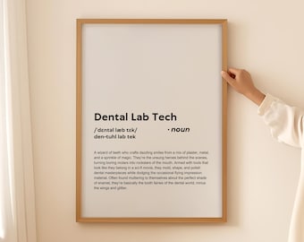 Op de afbeelding: Een ingelijst print met een witte achtergrond en zwarte tekst die de term "Dental Lab Tech" definieert. De tekst legt uit dat een tandtechnieker een "tandentovenaar" is die glimlachen creëert van gips, metaal en magie.