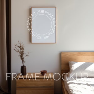 May include: A wooden bed frame with a white duvet and a white pillow. A wooden nightstand with a small brown bowl sits next to the bed. A framed picture with a white circle and text around it hangs on the wall behind the bed.