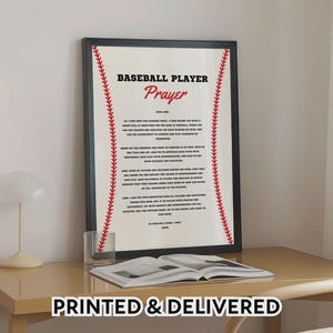 Puede incluir: Un cuadro con marco negro que presenta el texto Baseball Player Prayer en letras negras y rojas. El fondo es de color blanco roto con gráficos de costuras de béisbol rojas que corren verticalmente a lo largo de los lados izquierdo y derecho.