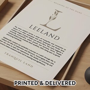 May include: A white rectangular print featuring the text MEANING OF THE NAME at the top, a large letter L with a botanical illustration, the name LEELAND, a paragraph describing the name, and the text TRANQUIL LAND at the bottom.