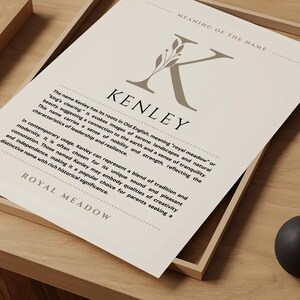 Può includere: Una stampa d'arte stampabile con uno sfondo marrone e una lettera K decorativa con foglie. Il testo "KENLEY" è in nero e il significato del nome è spiegato in marrone. Il testo recita: "Il nome Kenley ha le sue radici nell'antico inglese, che significa 'prato reale' o 'radure del re'. Evoca immagini di paesaggi sereni e bellezza naturale, suggerendo una connessione con la terra e una sensazione di tranquillità. Questo nome porta con sé un senso di nobiltà e forza, riflettendo le caratteristiche della leadership e della resilienza. Nell'uso contemporaneo, Kenley può rappresentare un mix di tradizione e modernità. Spesso viene scelto per il suo suono unico e la sua connotazione piacevole. Coloro che si chiamano Kenley possono incarnare qualità di creatività e indipendenza, il che lo rende una scelta popolare per i genitori che cercano un nome distintivo con un ricco significato storico." Il testo "ROYAL MEADOW" è in nero nella parte inferiore della stampa.