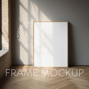May include: A wooden frame mockup with a white background, sitting on a light wood floor with a herringbone pattern. The frame is in a room with a large window and a grey wall.
