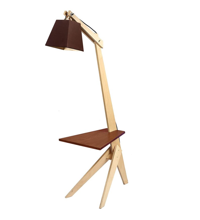 K&ouml;nnte beinhalten: Eine Stehlampe aus Holz mit einem braunen Stoffschirm und einem kleinen Regal. Die Lampe hat ein einzigartiges Design mit einem langen, abgewinkelten Arm und einem dreieckigen Sockel.