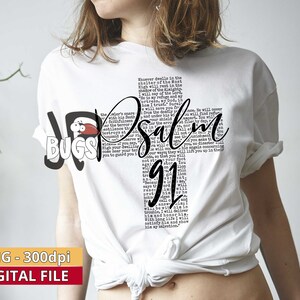 Pu&ograve; includere: Maglietta bianca con un design grafico in bianco e nero che presenta il testo "Salmo 91". Il testo &egrave; disposto in modo da creare una forma di croce. La grafica include anche una piccola illustrazione di un insetto rosso.