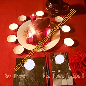 May include: A ritualistic scene with a red tablecloth, featuring a plate with a heart-shaped object lit by candles. Additional candles surround the plate. Two cards with white circles and text are present, along with a dark mug and red yarn. Text on the image: etsy.com/shop/AncientMagicalSpells, Real Photo!, Real Powerful Spell!