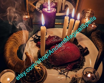 Puede incluir: Un plato blanco contiene dos objetos de color rojo oscuro en forma de corazón rodeados de hierbas secas y ramitas. Cuatro velas altas encendidas de color crema y una vela morada grande están presentes, junto a un cuerno, un incensario y frascos.