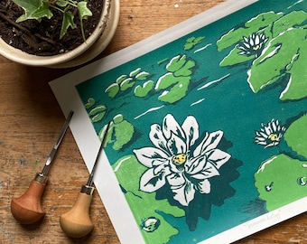 Może przedstawiać: Zielony i biały wydruk linorytny przedstawiający lilie wodne na tle turkusowym. Wydruk nosi tytuł "Summer Lily" i jest numerowany 1/15.
