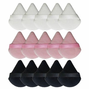 May include: A selection of twelve teardrop-shaped cosmetic powder puffs in white, pink, and black. Each puff features a ribbon handle for easy application. The puffs are arranged in rows, highlighting their soft, velvety texture. Ideal for applying makeup.