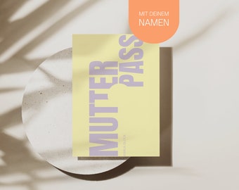 May include: A yellow card with the text "MUTTER PASS" in purple letters. The text "MIT DEINEM NAMEN" is in smaller letters at the top of the card.