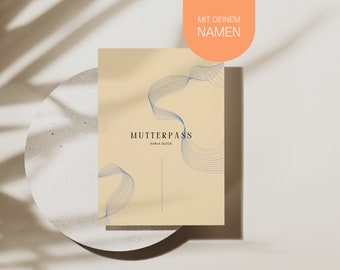 May include: A beige-colored document with the text "MUTTERPASS" and the name "KARLA GLOCK" in black. Blue wavy lines decorate the document. An orange label at the top reads "MIT DEINEM NAMEN".