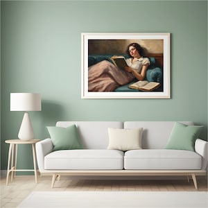 May include: A framed painting of a woman in a white dress and pink skirt, reclining on a teal couch and reading a book. The woman has dark hair and is looking down at the book. There is another book on the couch next to her.