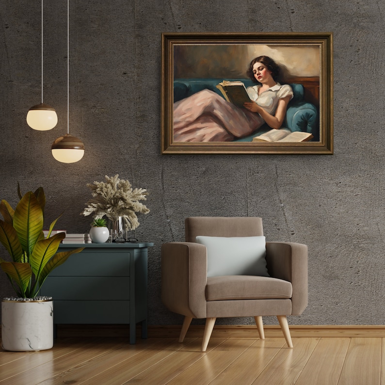 May include: A framed oil painting depicting a woman in a white dress and pink skirt, reclining on a blue couch and reading a book. The painting is set against a neutral background.