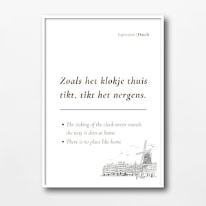 May include: A white framed print with a Dutch proverb in brown text: "Zoals het klokje thuis tikt, tikt het nergens."  The proverb translates to "There is no place like home."  The print also includes a black and white illustration of a windmill and houses.