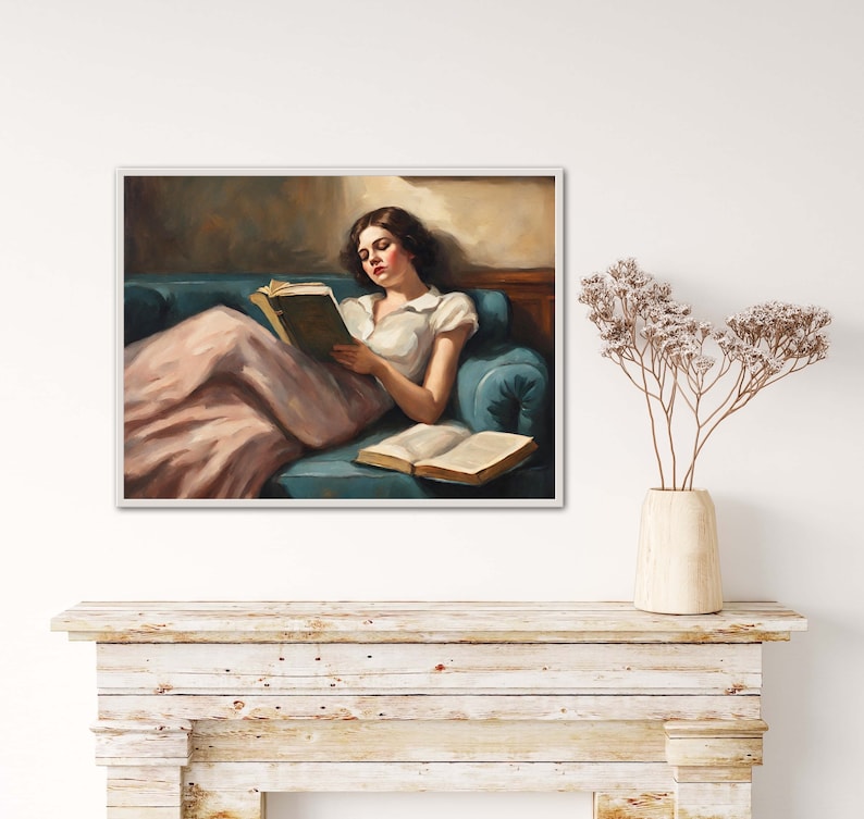 May include: A painting of a woman in a pink dress reading a book while reclining on a blue couch.