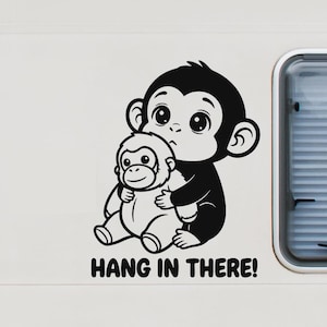 Könnte beinhalten: Schwarz-weißer Vinyl-Aufkleber mit zwei Cartoon-Affen. Der größere Affe umarmt den kleineren, mit dem Schriftzug "Hang in There!" darunter. Geeignet für verschiedene Oberflächen.