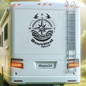 Könnte beinhalten: Weißes Wohnmobil mit schwarzem Kompass-Design und dem Text "Wunschtext Optional". Das Wohnmobil hat eine Leiter auf der Rückseite und steht in einer natürlichen Umgebung. Das Nummernschild lautet "Wepix24".