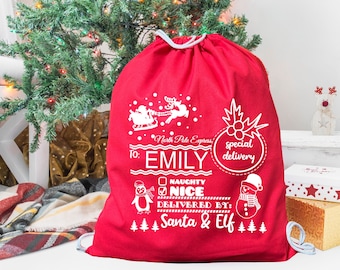May include: Red Christmas gift bag with white drawstring, featuring a Santa and reindeer design, the text "North Pole Express", and the words "To: Emily Special Delivery". The bag also has a penguin, snowman, and the text "Naughty Nice Delivered By: Santa & Elf".