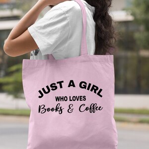 Puede incluir: Una bolsa de tela de color rosa claro con el texto "Just a girl who loves books & coffee" en negro.