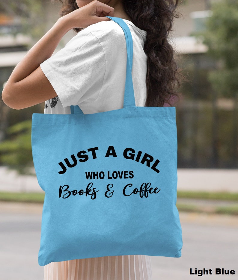 Puede incluir: Bolsa de tela azul claro con texto negro que dice "Just a girl who loves books & coffee".